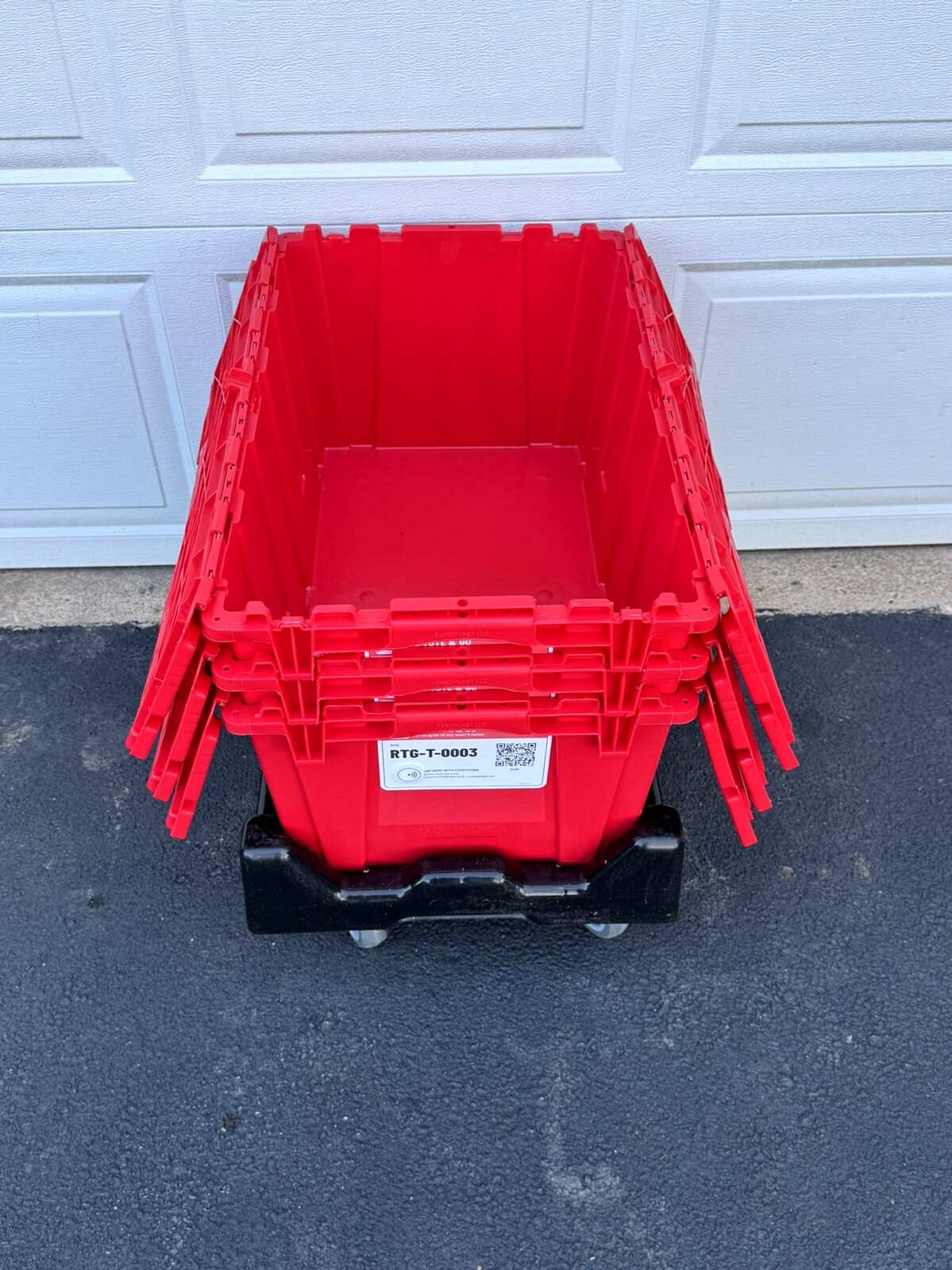A red moving tote open on top of the stack, its two lid halves folded back